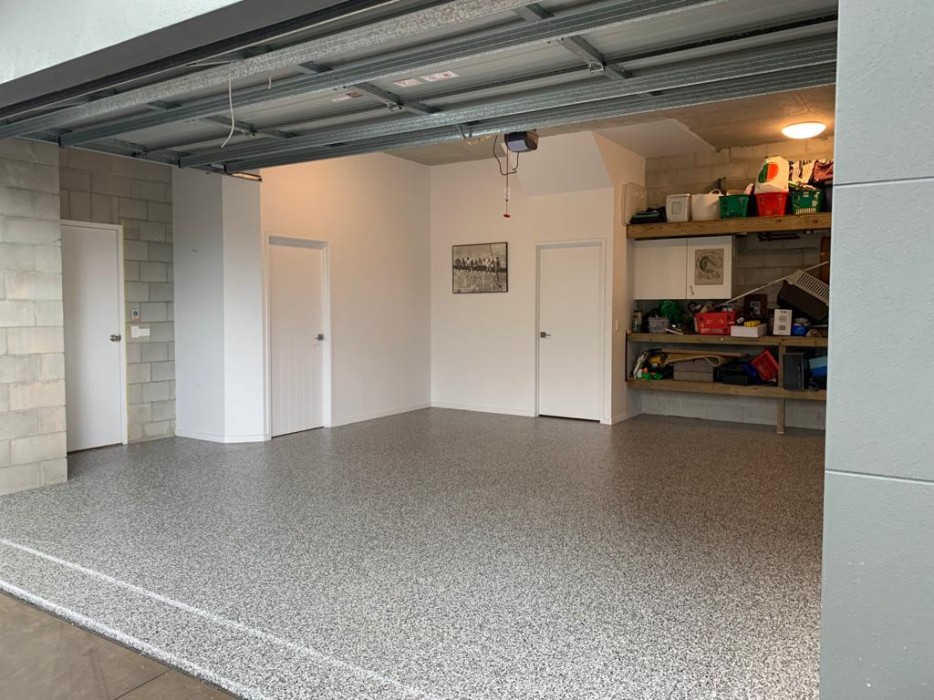 A photo looking into a residential garage with new epoxy flake garage flooring installed.